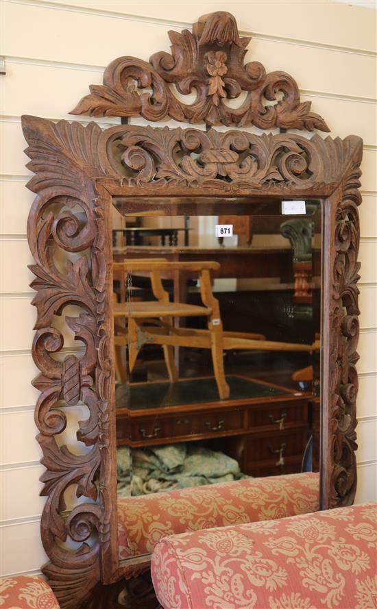 A Flemish style carved oak wall mirror, with bevelled plate, W.76cm H.115cm